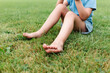 © ADDICTIVE STOCK - Crop child sitting on grass