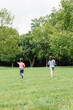 © ADDICTIVE STOCK - Kids running on lawn in park