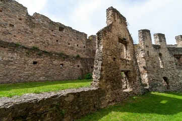 Sticker - Low angle of an old castle ruins in an evergreen field