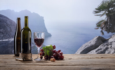 Image of two bottles and glass of wine standing on wooden table isolated over mountain background in early morning