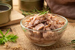 Close up Canned tuna in brine in glass bowl on wooden table