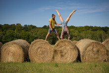 Caucasian Couple Doing Stunts On Straw Bales In France