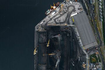 Wall Mural - Work of cranes in cargo port, loading black coal on ship for export. Aerial top view