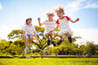 © famveldman - Happy kids play outdoor. Children skipping rope.