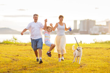 Wall Mural - Family with kids running outdoor at sunset.