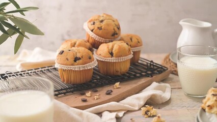 Canvas Print - Chocolate chip muffins with milk served on glass cups on white kitchen countertop.