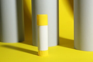 Canvas Print - Glue stick near paper rolls on yellow background