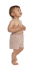 Poster - Cute baby in shorts learning to walk on white background