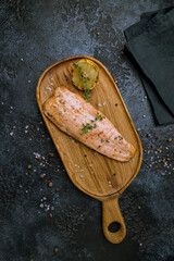 Wall Mural - Salmon steak on the grill on board on dark stone table top view