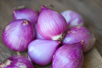 Wall Mural - fresh shallot for medicinal products or herbs and spices Thai food made from this raw shallot, Shallots or red onion, purple shallots on wooden background