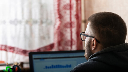 Young freelancer working at a computer at home, work remote from the office, home office