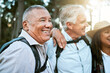 . Hiking, adventure and exploring with a carefree and excited male hiker with his senior friends outdoors. Enjoying a hike or walk in the forest or woods as a group of retired people for leisure.