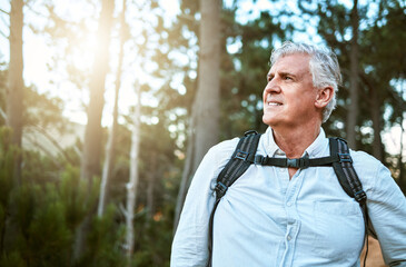 . senior man walking on hike in nature, looking at view on mountain and hiking on a relaxing getaway