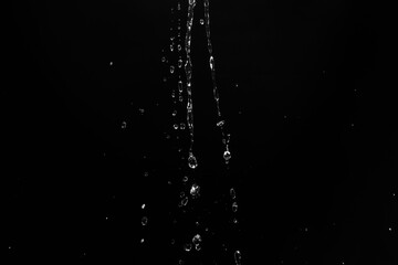 Poster - water splashes isolated on black background. white jets with drops