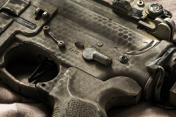 Wall Mural - Close-up shot of selective fire of khaki camouflage M4 assault rifle, to be adjusted to fire in safe, semi-automatic, fully automatic firearm
