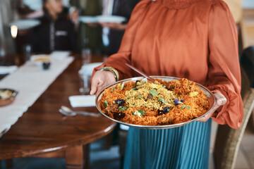 Wall Mural - Food, dinner and consumables with a traditional paella dish in the hands of a woman at home. Closeup of a bowl of spanish sea food, ready to serve and feed hungry family for lunch or healthy supper