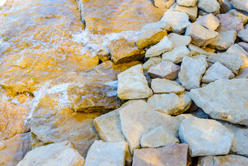 Beautiful cool and refreshing running stream along the stones and rocks on a bright summer day.Closeup.