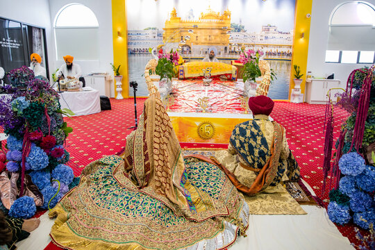 Indian Punjabi Sikh wedding at gurdwara, bride and groom back view
