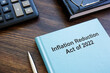 Leinwandbild Motiv Book with The Inflation Reduction Act of 2022 near calculator and notebook.