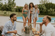 © BGStock72 - Group of young people cheering with drinks and eating fruits by the pool in the garden
