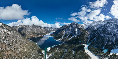 Wall Mural - dark blue icy water and snowy alps mountains of tyrol's natural jewel lake plansee