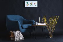 Interior And Home Decor Concept - Close Up Of Blue Chair, Coffee Table And Blanket In Basket In Dark Room