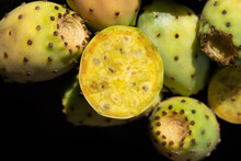 Close-up Of Fresh Prickly Pears Lying Against Dark Background. The Fruits Fall Sideways Into The Picture From Above.