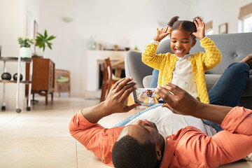 Happy father taking photo of funny little black girl