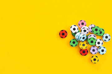 Wall Mural - Wooden figures in the form of soccer balls on a yellow background