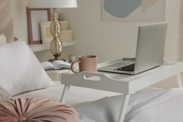 Poster - White tray table with laptop and cup of drink on bed indoors