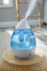 Wall Mural - Modern air humidifier on wicker pouf indoors