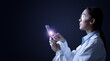 © Paulista - Side portrait of young female doctor touching tablet computer isolated on black background with empty space for text and image.