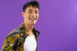 Portrait of happy biracial man looking at camera and smiling on purple background