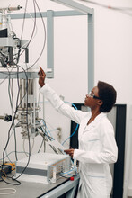 Scientist African American Woman Working In Laboratory With Electronic Tech Single Photon Detector. Research And Development Of Electronic Devices By Color Black Woman.
