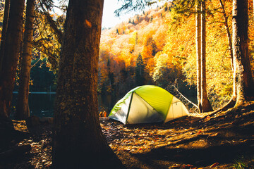 Wall Mural - Tent on shore by Bateti lake outdoors in fall in sunny beautiful autumn morning . Relaxation and travel outdoors in fall season concept
