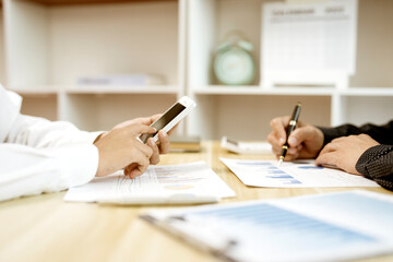 Poster - Two business people are sitting and looking at  graph and chart