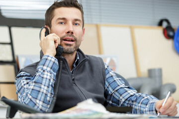 man sitting in office on the phone