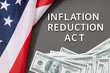 © Formatoriginal - Inflation reduction Act law concept. Fat lay of text, american flag and dollar banknotes