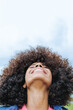 © Vane Nunes - Happy african american young woman looking up with sky on background - Focus on mouth