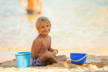 Sticker - Happy child on the beach, playing in the sand, enjoying summer