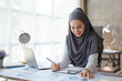 © aksonsat - Muslim business woman working on laptop with happy and smile face on office spec.