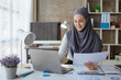© aksonsat - Muslim business woman working on laptop with happy and smile face on office spec.