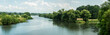 Panorama rzeki Odry w tle lekko pochmurna pogoda, błękit nieba zieleń przy brzegu,  pora letnia, Odra w odcinku województwa Opolskiego