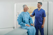 © Peakstock - Radiographer talking with male patient in hospital radiology department prior to CT scan being performed. Computed Tomography