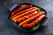 Traditional German barbecue Bratwurst sausages served in a rustic cast iron frying pan