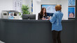 © DC Studio - Female patient paying consultation with credit card at reception desk, attending checkup visit appointment. Woman talking to receptionist to pay medical consultation at clinical counter.