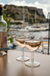 Rose wine in glasses served on outdoor terrace with view on old fisherman's harbour with colourful boats in Cassis, Provence, France