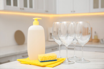 Canvas Print - Clean glasses and cleaning product on table in stylish kitchen