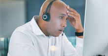 Shocked, stressed and annoyed call center agent having a bad day at work feeling unhappy and having problems. Tired, bored and frustrated male customer service consultant looking at his computer