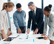 © Emily N/peopleimages.com - Finance, data and business people working on a graph in a modern office. Documents, teamwork and a multiracial group discuss project strategy with ceo or leader in a meeting in the boardroom.